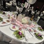 A round banquet table set for the Gonzales Gala with salads, drinks, menus, and a decorative crystal centerpiece, labeled table 15.